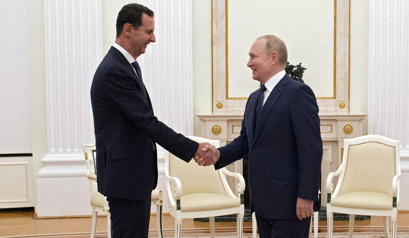 Russian President Vladimir Putin shakes hands with Syrian President Bashar al-Assad
